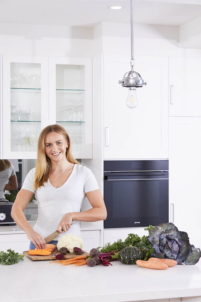 Ariarne Titmus cooking next to a Smeg steam oven.