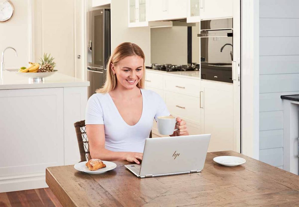 Ariarne Titmus using the HP Spectre x360 on her dining table.