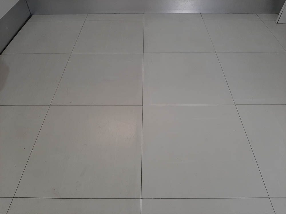 Left half of a tiled floor is dirty, while the right half is clean after using the Karcher SC 5 Premium Steam Cleaner.