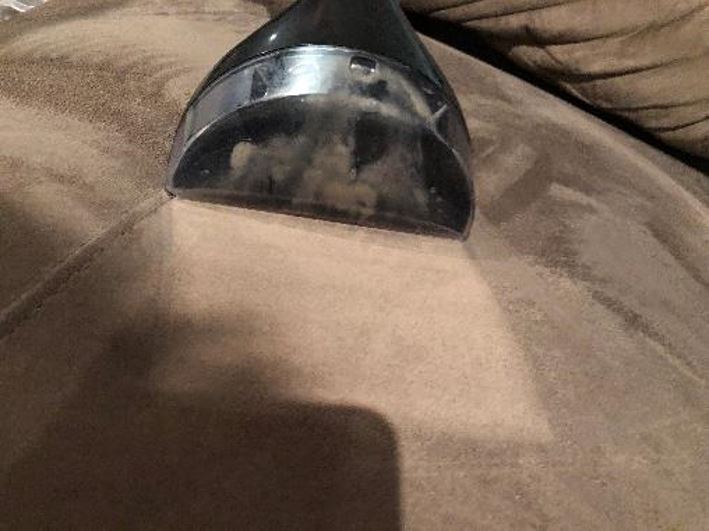 The BISSELL SpotClean Turbo Professional Portable Carpet & Upholstery Washer removing dirt from a lounge.