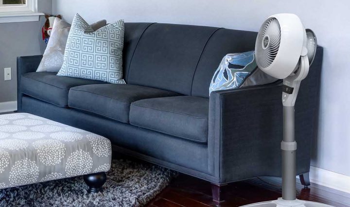 The Vornado’s Energy Smart™ Pedestal Air Circulator next to a couch.