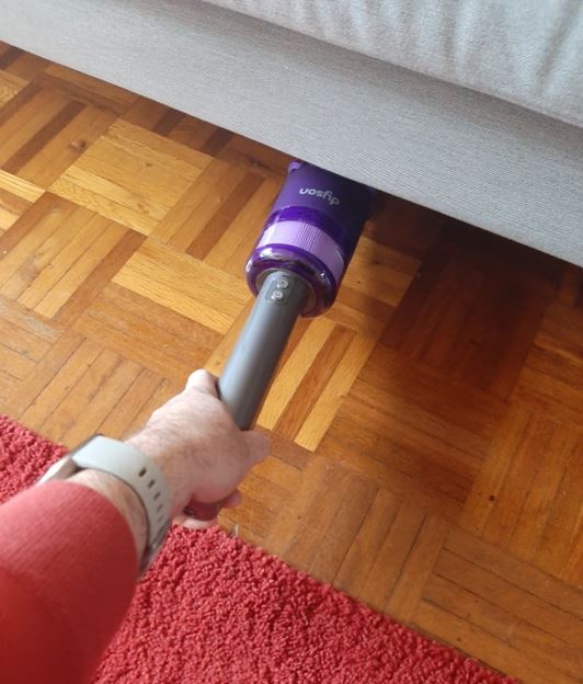 Vacuuming under a lounge with the Dyson Omni-glide.