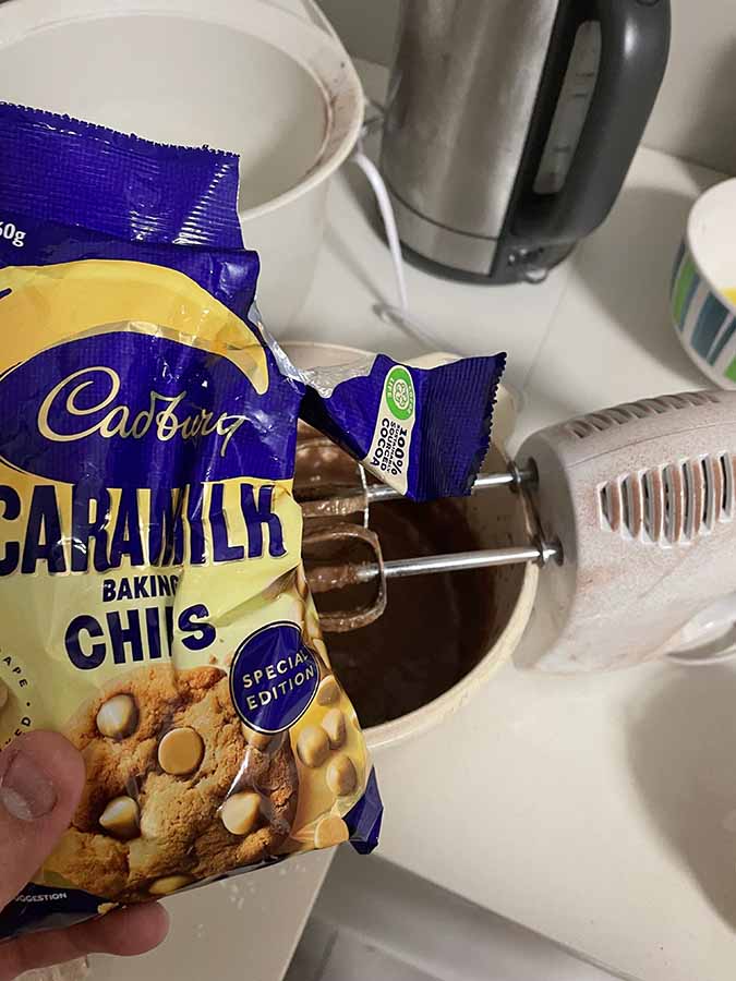 Добавление чипсов Cadbury Caramilk Baking Chips во взбитый шоколад.