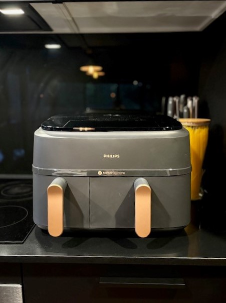 Philips 3000 Series XXXL Air Fryer set on a dark grey kitchen benchtop, next to a ceramic cooktop.