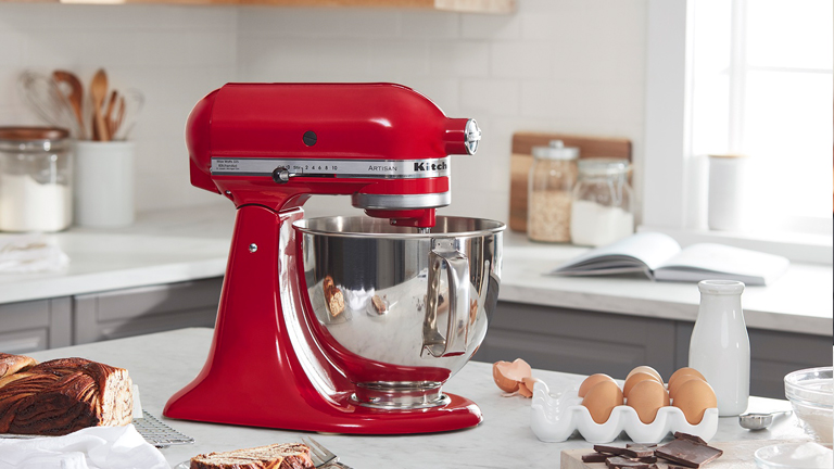 Premium AI Image  A blue kitchenaid mixer with a pink stand mixer on a  wooden table.