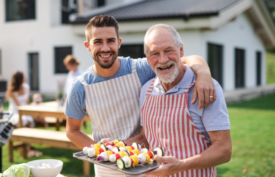 Father and adult son enjoying a backyard barbecue together 