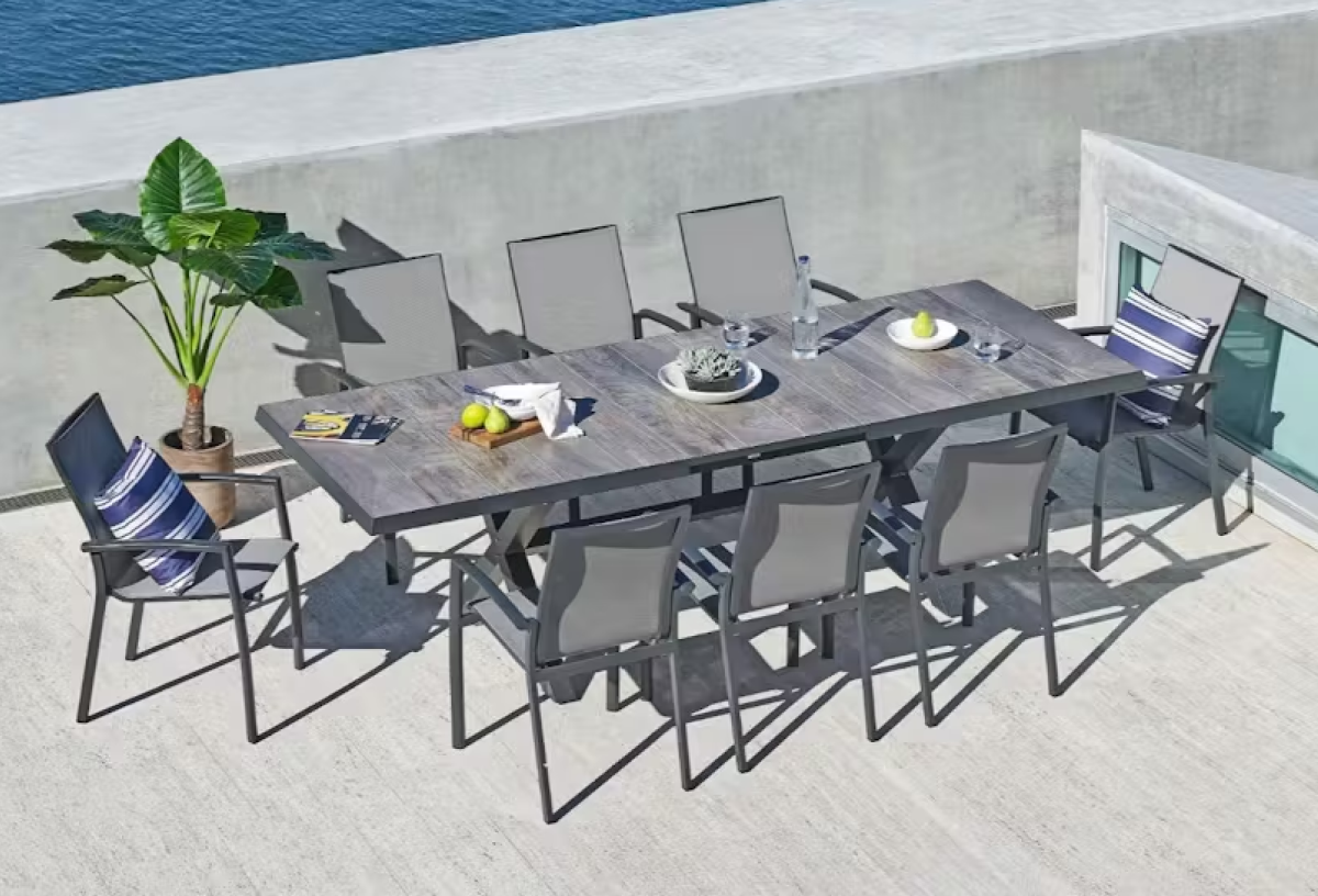 Harvey Norman exclusive Parsons 9-piece graphite outdoor extension dining setting with eight chairs on a poolside patio. 