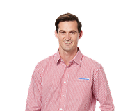Male Harvey Norman staff member wearing red striped uniform smiling against white background 
