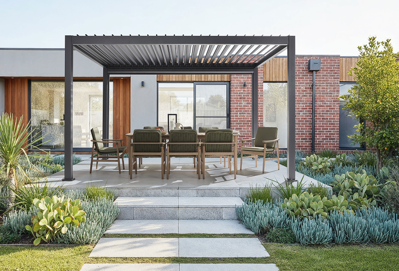Freestanding charcoal gazebo with adjustable louvred roof above an outdoor dining setting in a modern garden.