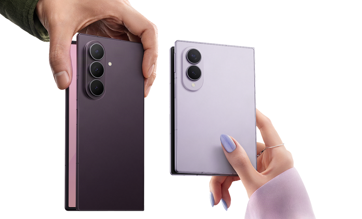 Two hands hold an open Galaxy Z Fold8 Ultra and wider Galaxy Z Fold8, with their rear cameras and contrasting finishes visible.